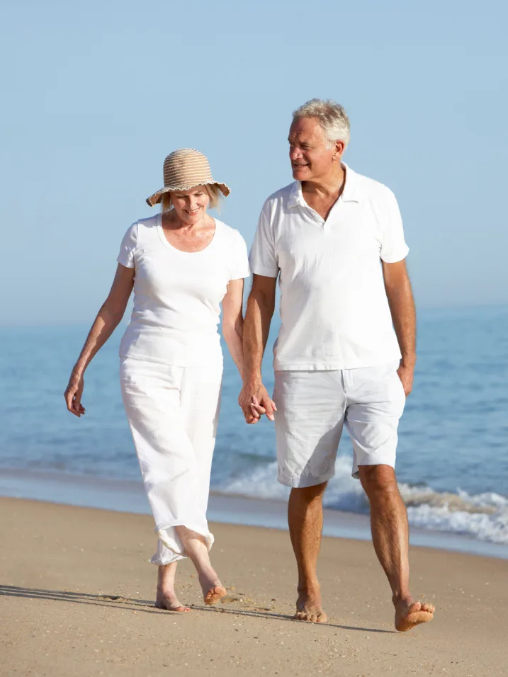 A couple walking the shoreline in Naples