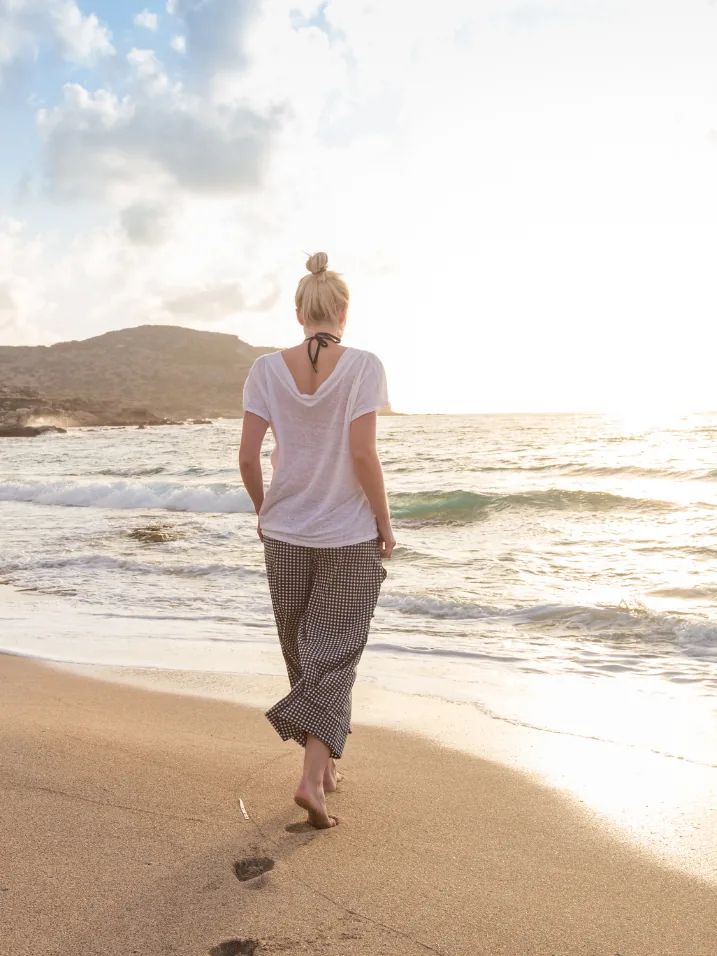 A woman walking alone along the shoreline