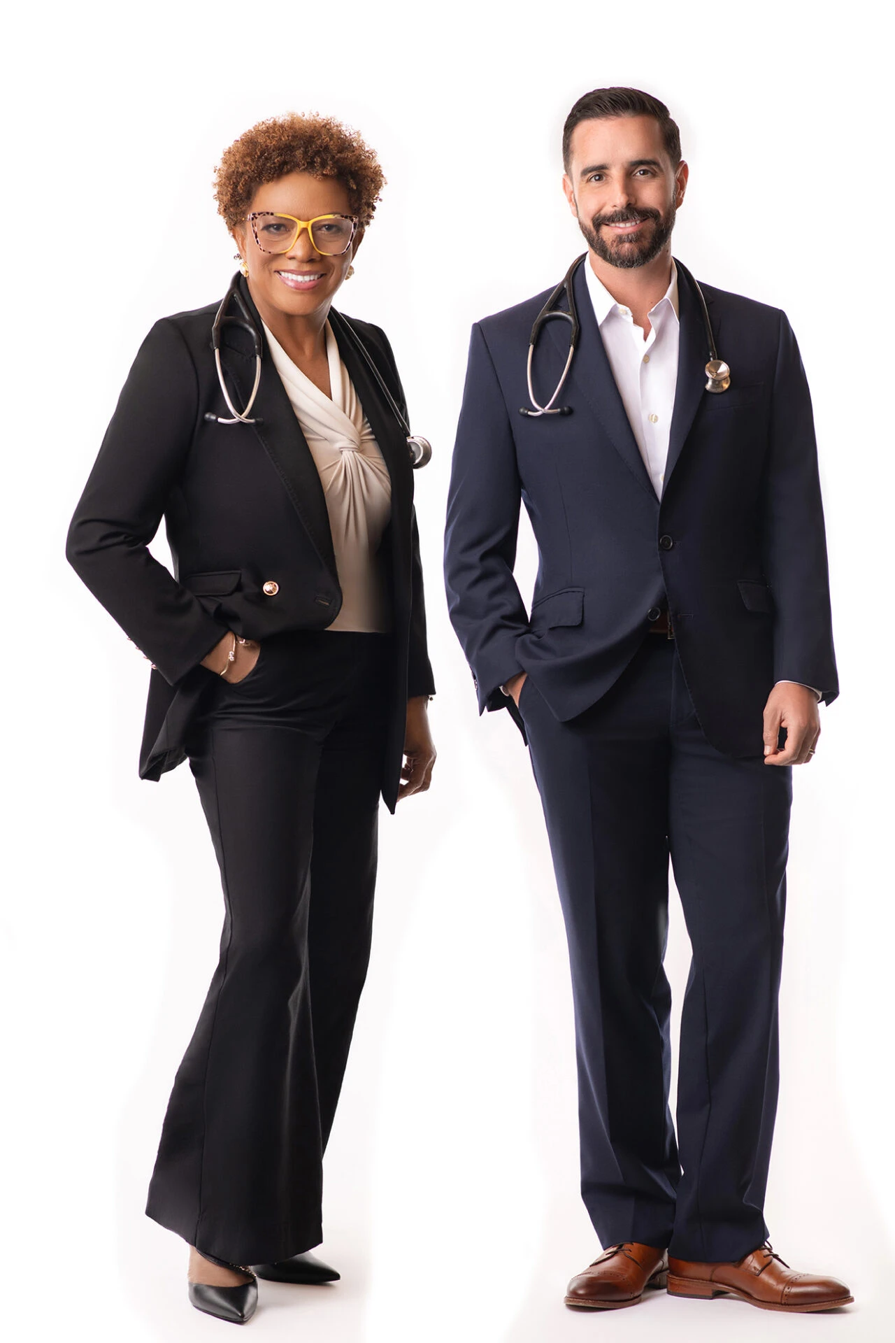 Two women participating in a pilates class, focusing on their movements on exercise mats in a well-lit environment.